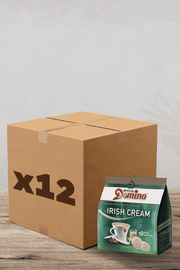Une boîte pratique marquée « x18 » se trouve de manière invitante à côté d'un paquet de Café Dosettes Domino Irish Cream compatibles pour les machines Senseo. La surface en bois et le fond uni laissent briller l'essentiel : un café délicieux et sans tracas pour votre plus grand plaisir. Parfait pour les amateurs de café ! | Flaronis.lu