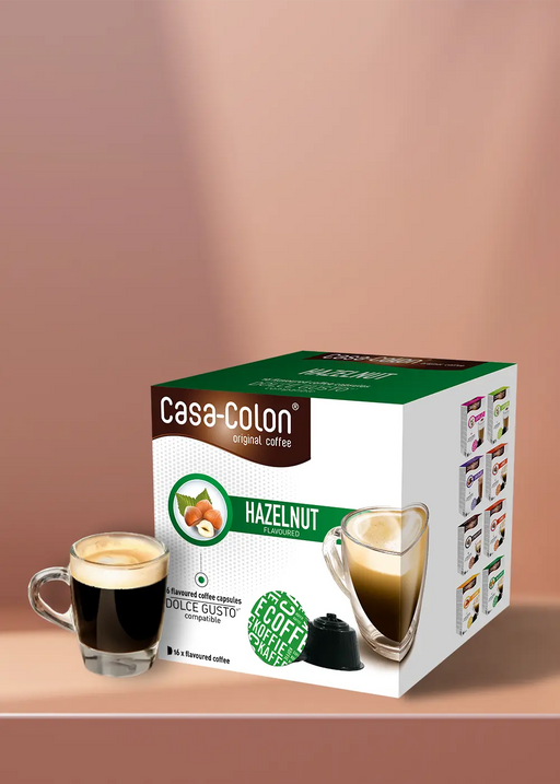 Laissez-vous tenter par la riche saveur de la noisette de Casa Colon avec nos capsules compatibles Dolce Gusto. Chaque boîte contient 16 dosettes de café de qualité supérieure, parfaites pour la cuisine de tout amateur de café. Il suffit de préparer le café, de le verser dans votre verre préféré et de savourer le goût irrésistible du café aux noisettes fraîchement préparé. | Flaronis.lu