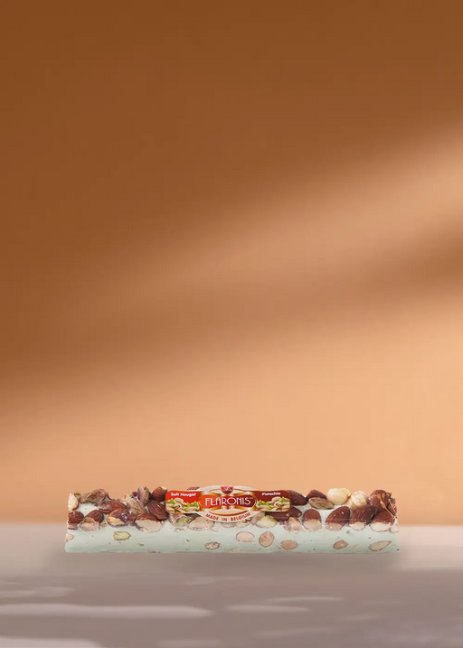 Un délicieux mélange de noix trône de manière invitante sur une surface claire, parfaitement encadrée par un fond riche de couleur café. | Flaronis.lu