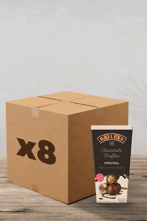 À côté d'un paquet de truffes au chocolat au lait et à la crème irlandaise Baileys (135 g) se trouve une boîte en carton étiquetée « x8 », le tout joliment exposé sur une surface en bois. Des friandises parfaites pour tout amateur de café ! | Flaronis.lu