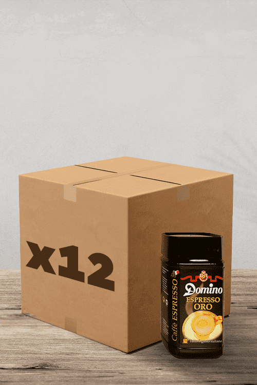 Une boîte en carton étiquetée « x12 » se trouve à côté d'un pot de Café Soluble Espresso Oro Domino – 100 g sur une surface en bois rustique, parfaite pour les amateurs de café. | Flaronis.lu