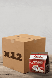 Imaginez un coin café confortable : une boîte en carton marquée "x12" se trouve de manière invitante à côté d'un paquet de crème de cappuccino Domino originale riche et aromatique. A proximité, vous trouverez un pack de dosettes Café Domino Cappuccino Compatibles Senseo - 18 dosettes. Tout cela est soigneusement disposé sur une surface en bois chaleureuse sur un fond simple, créant la configuration parfaite pour votre prochaine délicieuse expérience de café. | Flaronis.lu