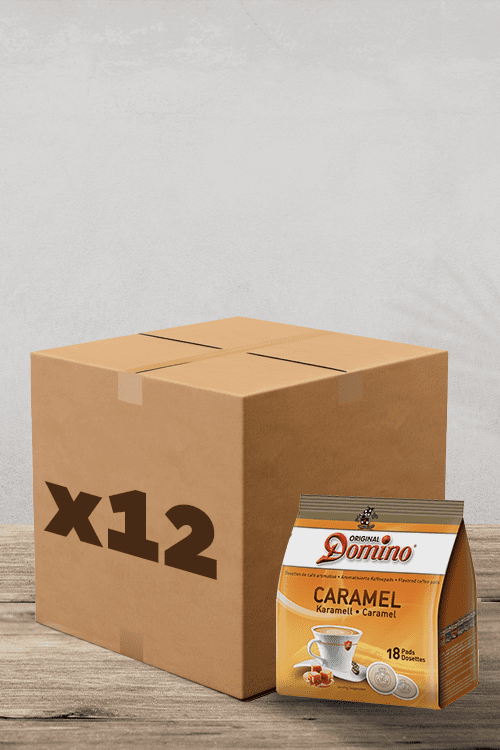 A côté d'une grande boîte en carton "x12", vous trouverez un sachet de dosettes Café Domino Caramel Compatibles Senseo. Chaque sachet contient 18 délicieuses dosettes de café au goût caramel. L'ensemble de la configuration est élégamment affiché sur une surface en bois sur un fond gris élégant, parfait pour tout amateur de café cherchant à améliorer son rituel matinal ! | Flaronis.lu
