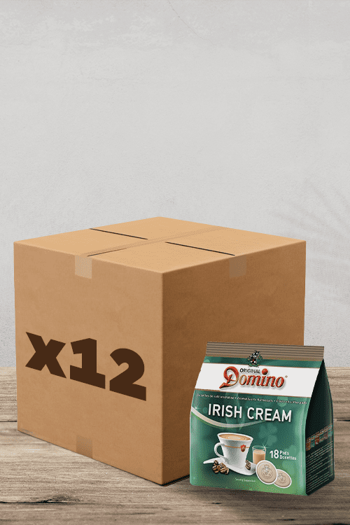 Une boîte pratique marquée « x18 » se trouve de manière invitante à côté d'un paquet de Café Dosettes Domino Irish Cream compatibles pour les machines Senseo. La surface en bois et le fond uni laissent briller l'essentiel : un café délicieux et sans tracas pour votre plus grand plaisir. Parfait pour les amateurs de café ! | Flaronis.lu