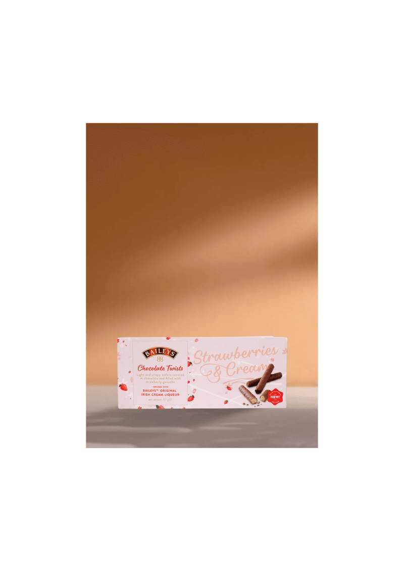 Accompagnez votre café d'une délicieuse friandise : Biscuits au chocolat fourrés à la crème irlandaise Baileys et aux fraises (107 g). Joliment présentés sur un fond beige chaud et accueillant avec de douces ombres, ils sont parfaits pour les amateurs de café à la recherche du compagnon sucré idéal pour leur boisson préférée. | Flaronis.lu