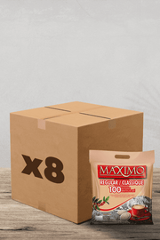 Une scène chaleureuse vous attend ! Une boîte en carton marquée « x 8 » se trouve à côté d'un sac de dosettes de café Maximo Classique de Pack Café : 100 dosettes compatibles Senseo prêtes à être infusées sur un comptoir en bois. Amateurs de café, soyez impatients de savourer votre infusion préférée en toute simplicité et commodité ! | Flaronis.lu