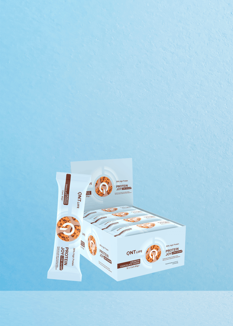 Présentation de la boîte QNT Protein Joy Cookie and Cream : un régal délicieux pour les amateurs de café ! Chaque boîte contient 12 paquets de délicieuses barres de 60 g, parfaitement complétées par une barre élégamment posée contre la boîte. Dotée d'un fond texturé bleu clair qui évoque la sérénité, cette friandise se marie à merveille avec votre tasse de café préférée pour une expérience délicieuse. Offrez-vous un délice spécialement optimisé pour ceux qui chérissent leurs moments de café. | Flaronis.lu