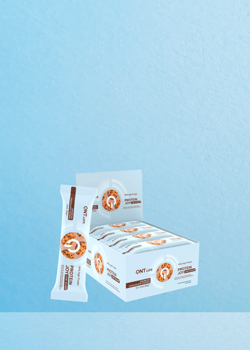 Présentation de la boîte QNT Protein Joy Cookie and Cream : un régal délicieux pour les amateurs de café ! Chaque boîte contient 12 paquets de délicieuses barres de 60 g, parfaitement complétées par une barre élégamment posée contre la boîte. Dotée d'un fond texturé bleu clair qui évoque la sérénité, cette friandise se marie à merveille avec votre tasse de café préférée pour une expérience délicieuse. Offrez-vous un délice spécialement optimisé pour ceux qui chérissent leurs moments de café. | Flaronis.lu