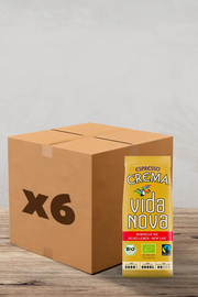Sur une surface en bois, vous trouverez une boîte en carton étiquetée « x6 » à côté d'un paquet jaune vif de « Café en Grains Vida Nova Espresso Bio & Fairtrade - 1 kg ». Ce paquet arbore fièrement le logo Fairtrade, gage d'un café issu de sources éthiques. Idéal pour les amateurs de café qui apprécient la qualité et la durabilité, ce coffret vous invite à savourer de riches saveurs d'espresso à chaque infusion. | Flaronis.lu